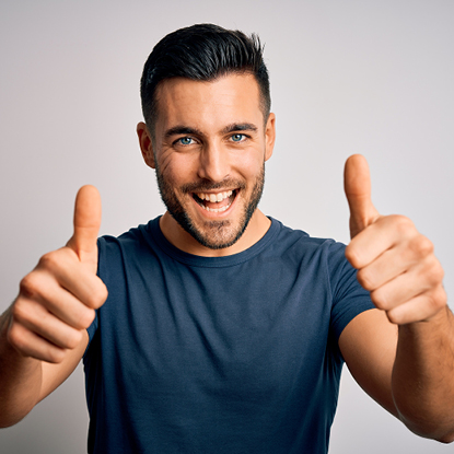 Man is smiling while doing a thumbs up.